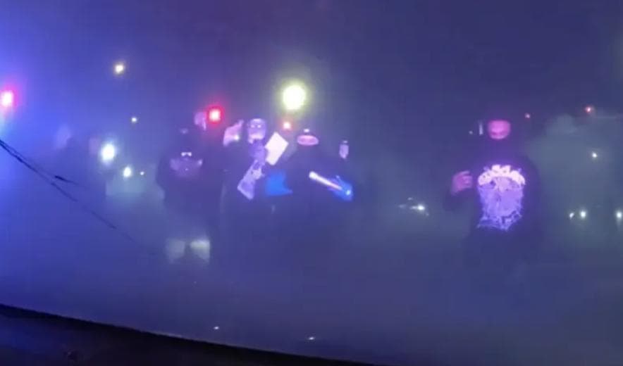 Masked Individuals Surround Patrol Car With Police Inside