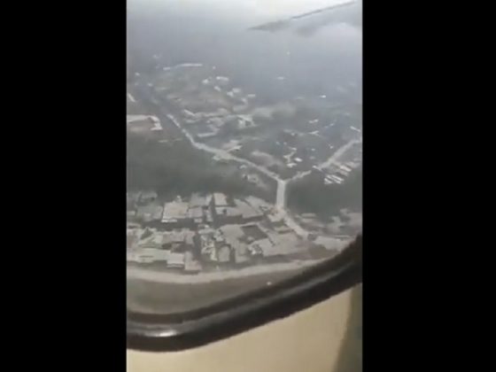 A view out a plane window shows the ground is close.
