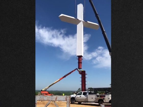 Hundreds stopped to watch a crew raise the cross Thursday in Priceville, Alabama.
