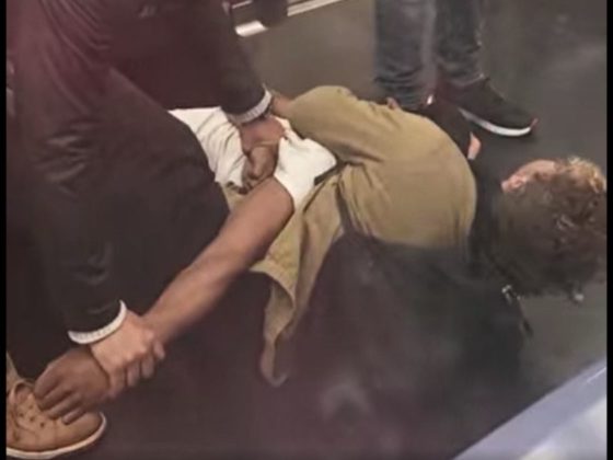 A homeless, mentally disturbed man is restrained by subway passengers in New York City.
