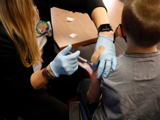 A 8 year-old child receives their first dose of the Pfizer Covid-19 vaccine at the Beaumont Health offices in Southfield, Michigan on November 5, 2021. (Photo by JEFF KOWALSKY / AFP) (Photo by JEFF KOWALSKY/AFP via Getty Images)