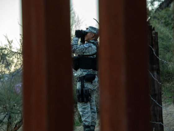 A US National Guard soldier (R) patrol at the US-Mexico border fence in Jacumba, California, on December 6, Hundreds of migrants who cross into the United States each day are being herded into open-air camps, where they have no access to food or water, with some are left to sleep on the open ground in a desert riddled with scorpions and snakes, activists say. (Photo by VALERIE MACON / AFP) (Photo by VALERIE MACON/AFP via Getty Images)