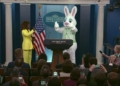 White House press secretary Karine Jean-Pierre with a character in a rabbit suit at the press room podium on Monday.