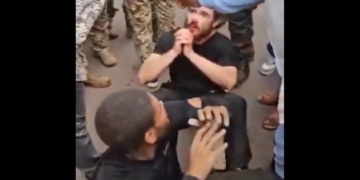 Two man sit on the ground surrounded by Congolese soldiers after a coup attempt Sunday in Kinshasa, the capital of the Democratic Republic of Congo.