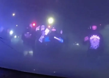 Masked Individuals Surround Patrol Car With Police Inside